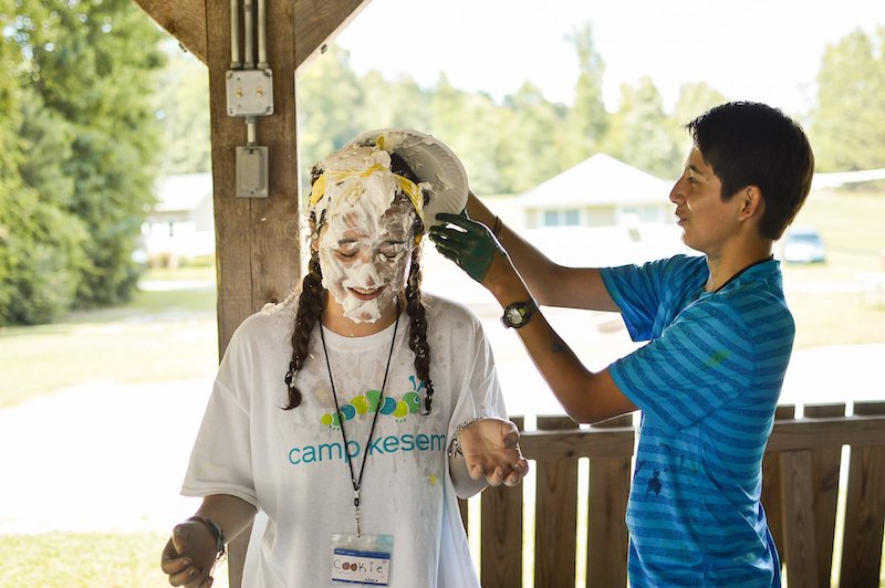 this photo shows a girl at George Mason University's Camp Kesem event getting a bunch of goop poured on her head