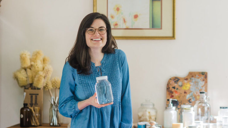 this photo shows Michaela Barnett, founder of KnoxFill, holding one of her refillable containers