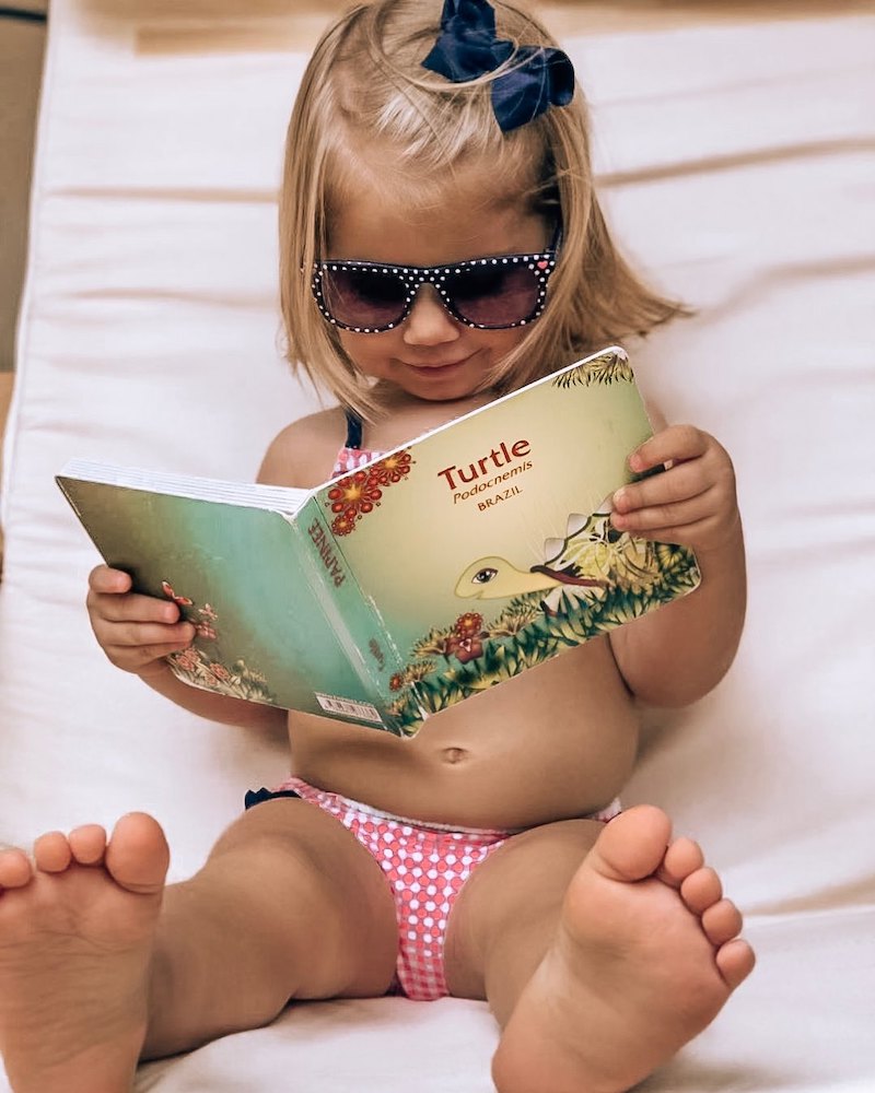 photo of a small child reading a Papinee book that ties into the company's children's programming for YouTube during the pandemic