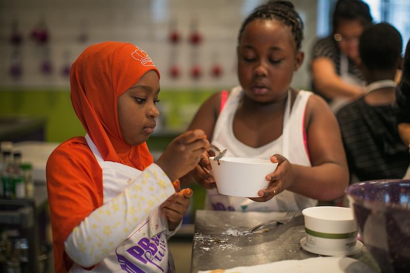 this photo shows two children preparing food for the needy at the PB&J Fund.