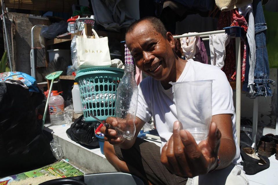 this is a photo of a man sorting through plastic waste for the Plastic Bank