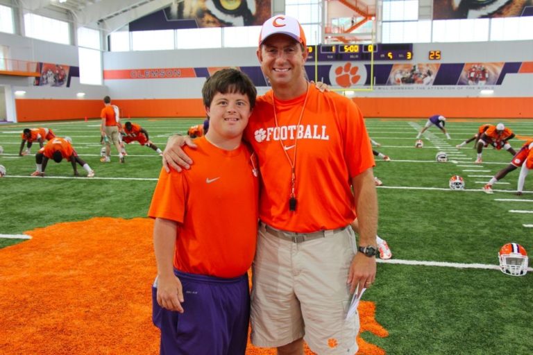 this photo shows Dabo Swinney, a major supporter of the Shepherd Hotel, with a person with special needs.