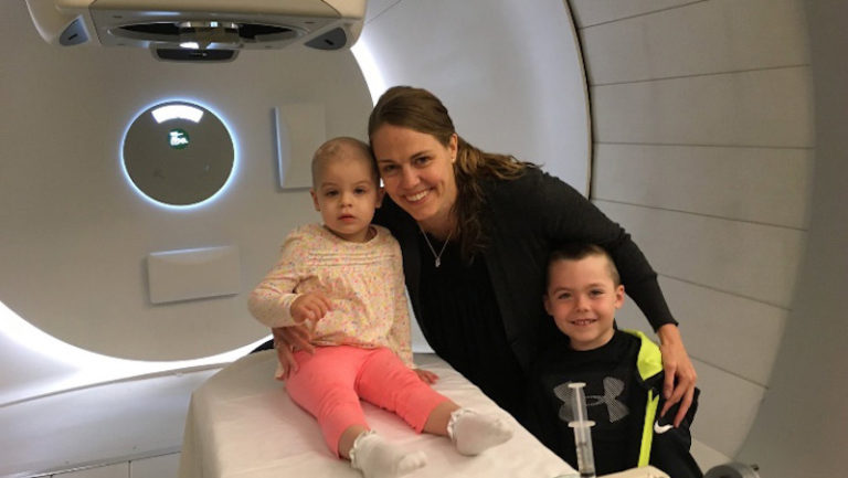 this photo shows Teagan Fettig, a little girl with cancer, at an MRI machine with her mother Tatum Fettig, who co-created the Community Heals app