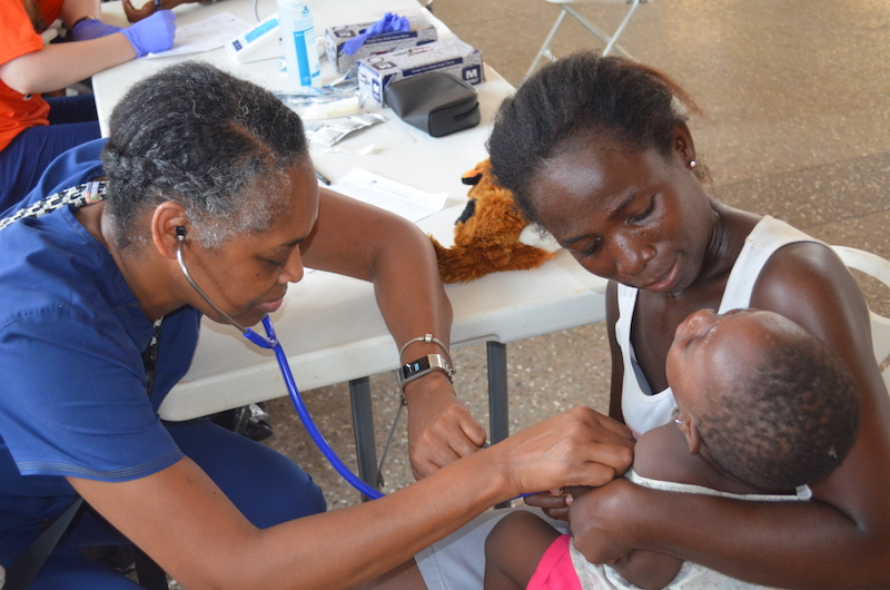 this photo shows Auburn University's Valarie Thomas performing a medical checkup on a baby in Ghana as part of the Ghana Healthcare Program.