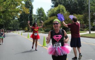 this photo shows three participants dressed in superhero costumes for the Great Cape Race hosted by Elon University