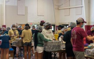 this photo shows student volunteers at Elon University packing meals for Rise Against Hunger