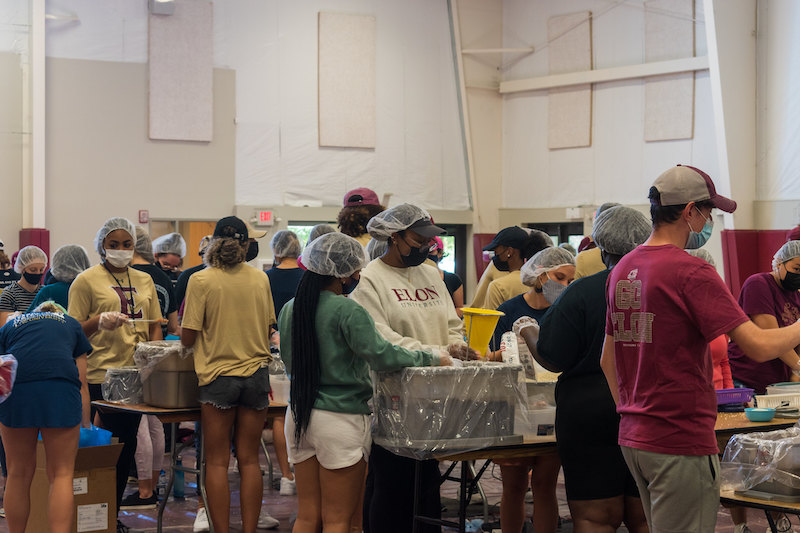 this photo shows student volunteers at Elon University packing meals for Rise Against Hunger