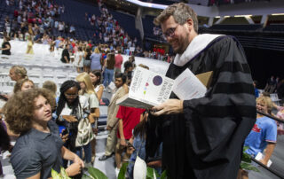 Author John Green signs a book for a student at the University of Mississippi's fall convocation.