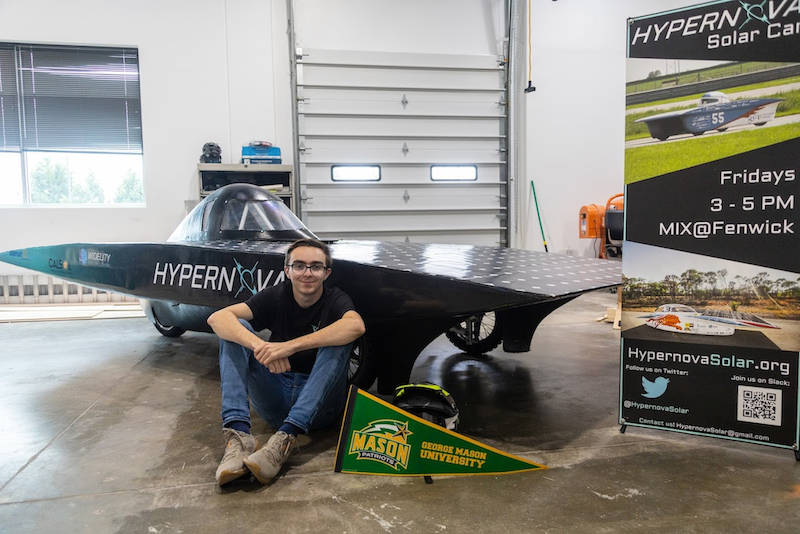 This photo shows Michael Riggi, a student at George Mason University, in front of a prototype for a 3D-printed solar car